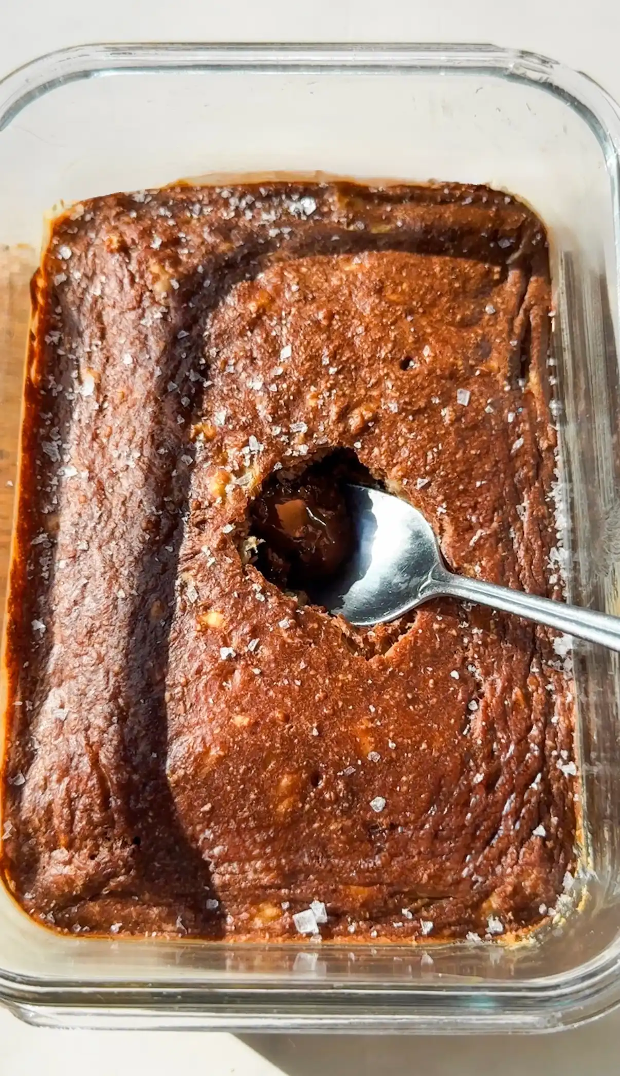 A chocolate banana pancake bowl in an oven-safe dish with a melted dark chocolate centre, served warm