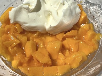 Step 3: Adding spoonfuls of mango yogurt mixture into chocolate-lined silicone molds