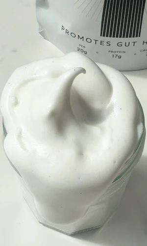 Close-up of vanilla bean marshmallow fluff swirled into a peak on top of a glass jar